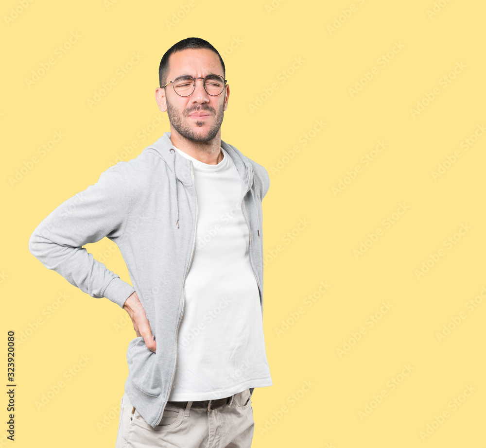 Tired young man posing against background Tired young man posing against background