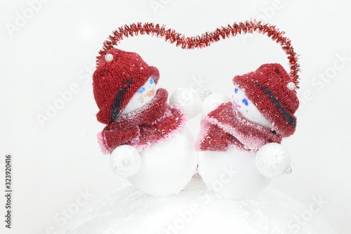  a pair of snowmen under the red outline of the heart