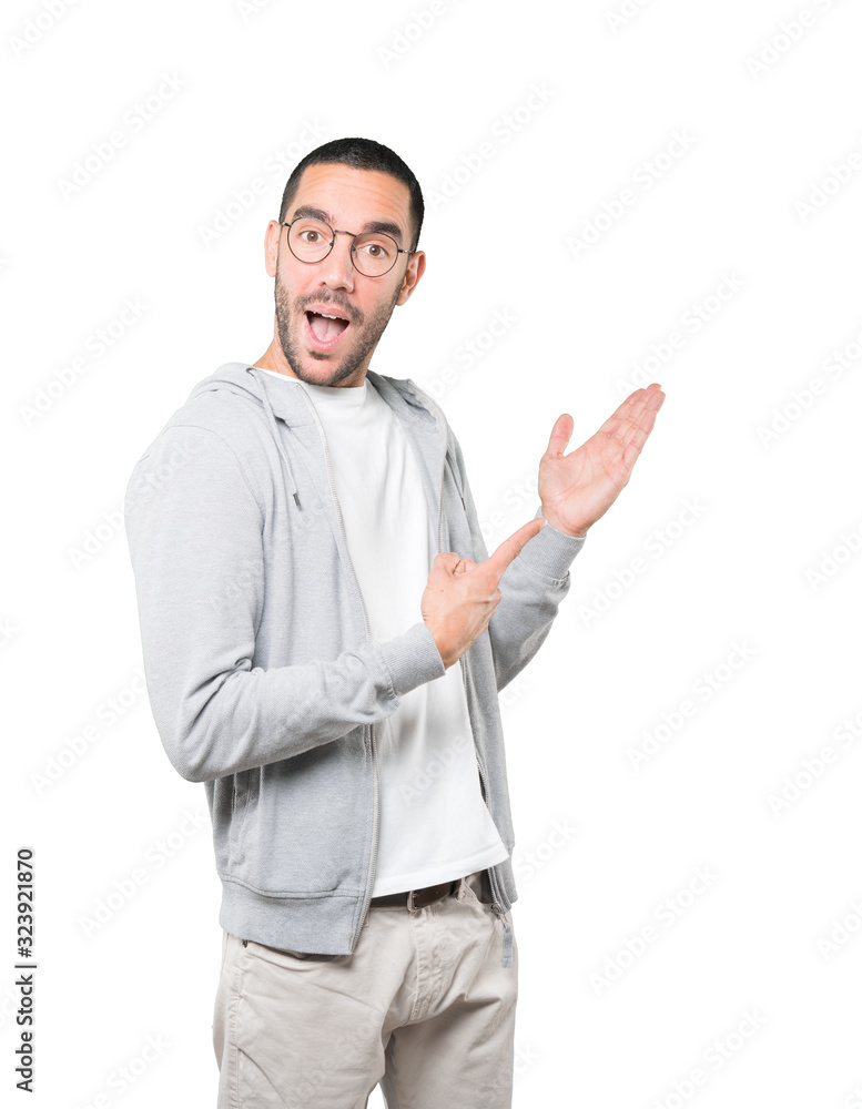 Amazed young man making a gesture of welcome Amazed young man making a gesture of welcome
