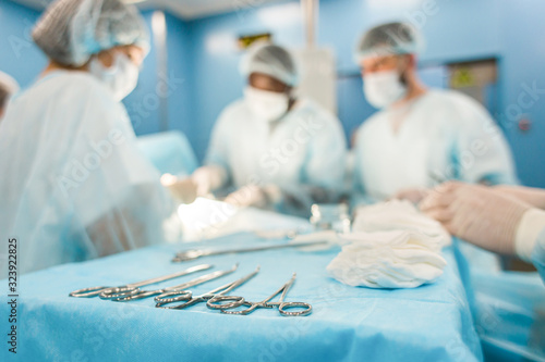 Tools for the operation in the foreground and a team of surgeons in the background performing the operation