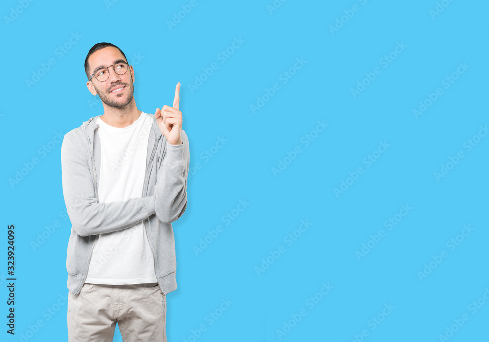 Happy young man pointing up with his finger Happy young man pointing up with his finger