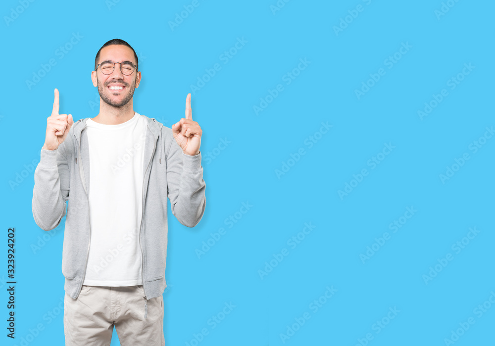 Amazed young man pointing up with his finger Amazed young man pointing up with his finger