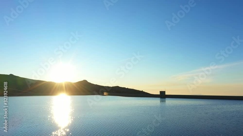 Aerial, drone shot, over lake Lagoa Comprida and Maques da silva dam, towards the sunset, Serra da Estrela, Guarda, Portugal