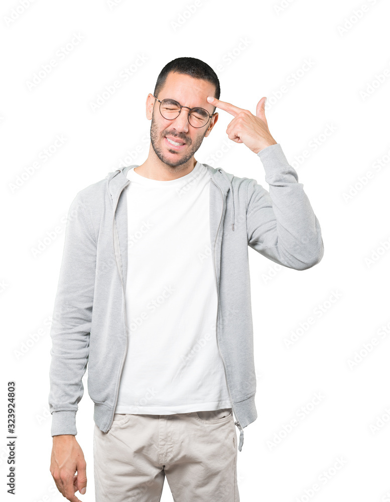 Depressed young man making a suicide gesture Depressed young man making a suicide gesture