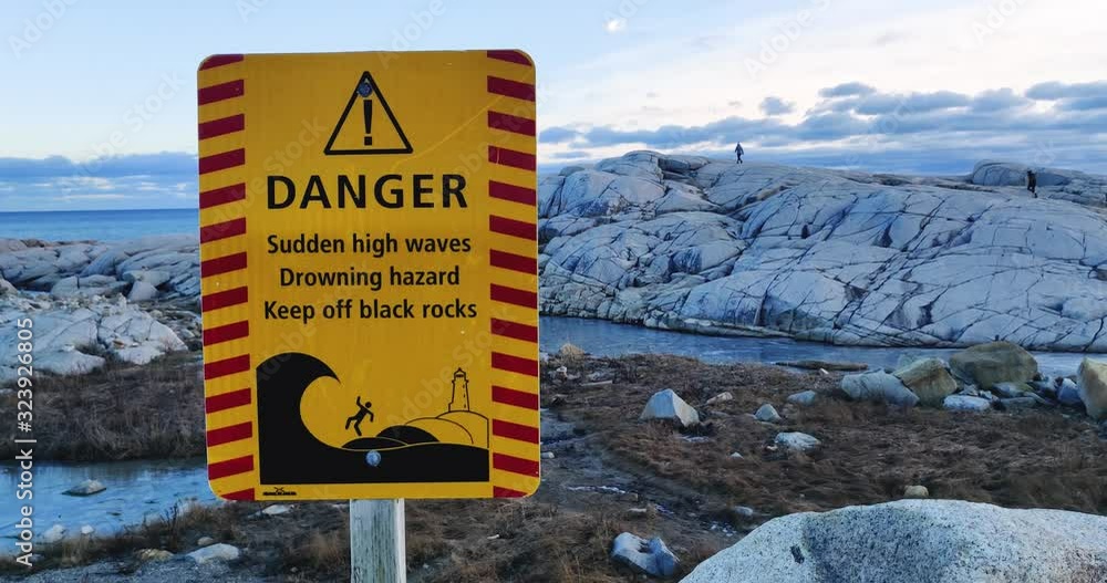 Vidéo Stock Danger Warning sign of slippery black rocks and drowning ...