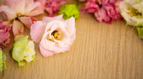 partially blurred background of wilted flowers in close-up on a wooden background © Nady