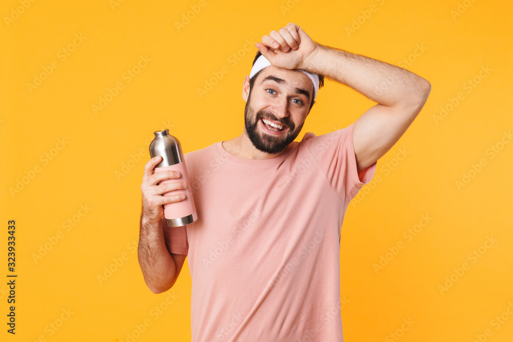 Image of tired athletic young man in t-shirt holding water bottle Image of tired athletic young man in t-shirt holding water bottle