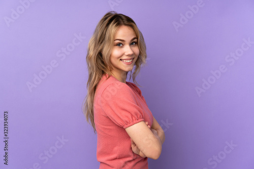 Teenager Russian girl isolated on purple background with arms crossed and looking forward