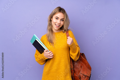 Teenager Russian student girl isolated on purple background celebrating a victory