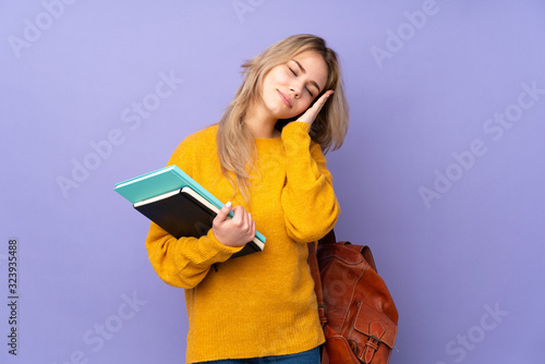 Teenager Russian student girl isolated on purple background making sleep gesture in dorable expression