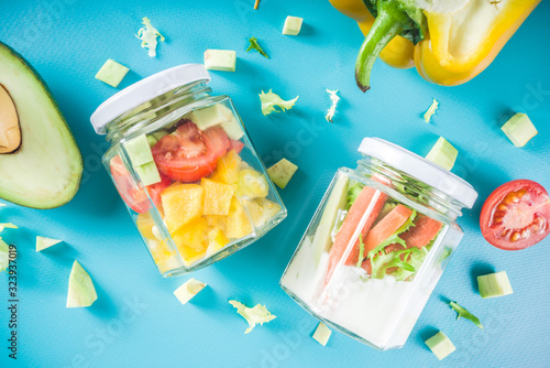 Healthy take-away lunch jar. Vegan vegetable salad in glass jars, with sliced fresh vegetables. Detox, raw eating and zero waste lunch concept photo