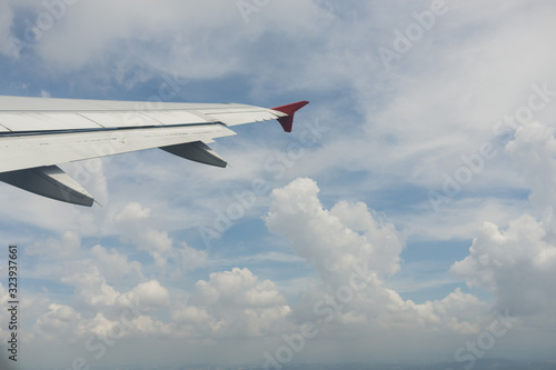 Photo from the window of an airplane. View from above on clouds and the earth. High. Sunny and cloudy day. Photo with telephone. View of the sky.