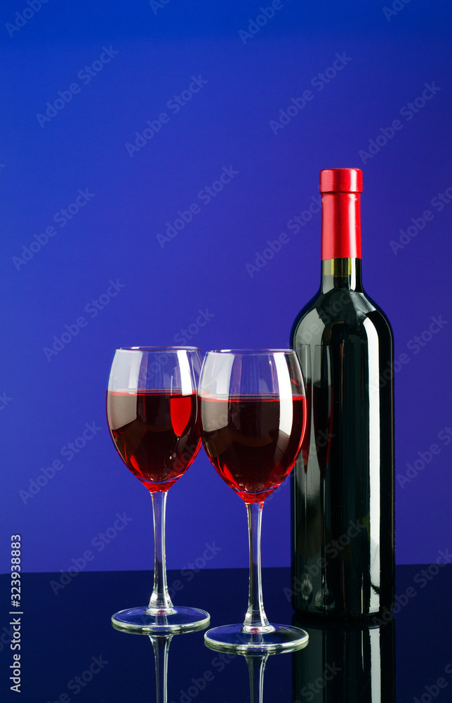 Glasses and bottle of wine on bright blue background Glasses and bottle of wine on bright blue background