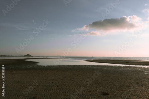 Beautiful yellow or golden sunset on the sea in Thailand on Koh Samui. Calm and low tide. Panorama of how to set the sun. Palms and hills and boats