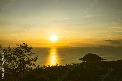 Beautiful yellow or golden sunset on the sea in Thailand on Koh Samui. Calm and low tide. Panorama of how to set the sun. Palms and hills and boats