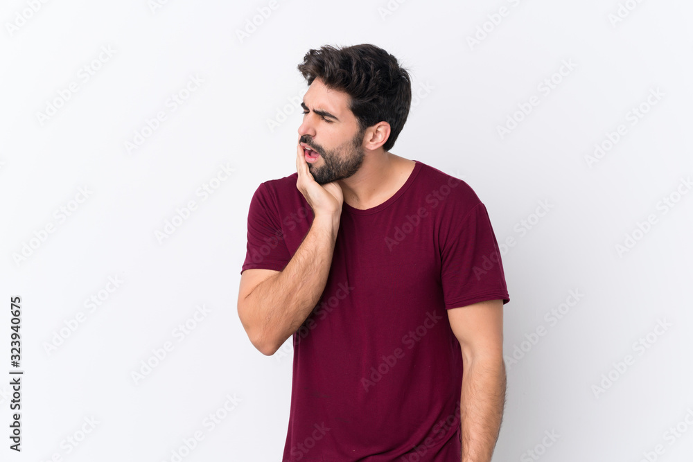 Young handsome man with beard over isolated white background with toothache Young handsome man with beard over isolated white background with toothache