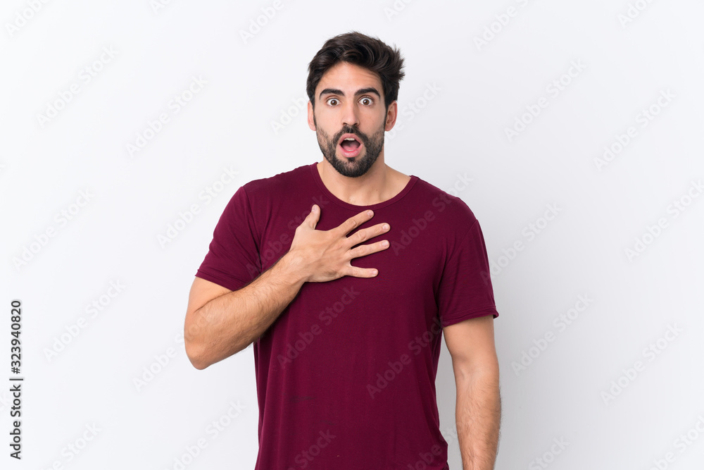 Young handsome man with beard over isolated white background surprised and shocked while looking right Young handsome man with beard over isolated white background surprised and shocked while looking right