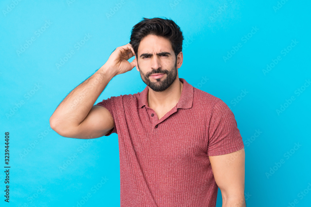 Young handsome man with beard over isolated blue background having doubts Young handsome man with beard over isolated blue background having doubts