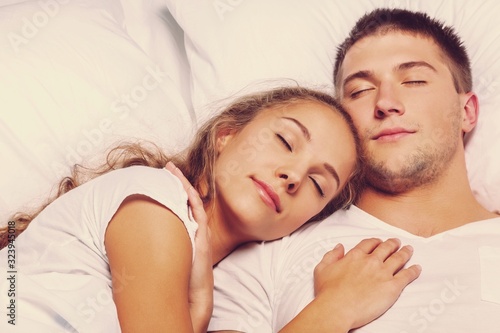 Woman and man couple sleeping together in bed