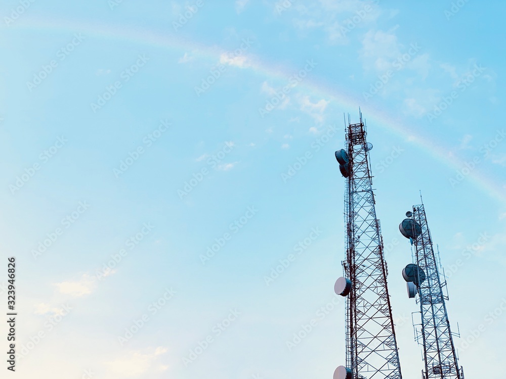 Obraz premium antenna on blue sky with rainbow.