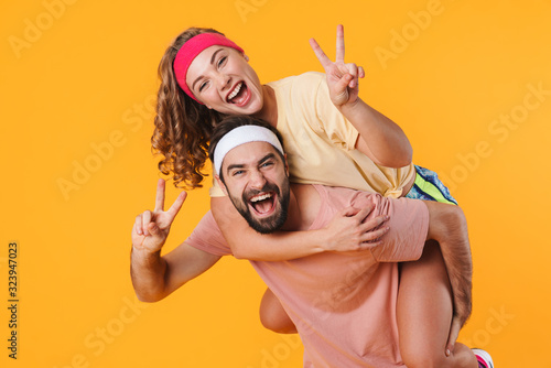 Fototapeta Naklejka Na Ścianę i Meble -  Portrait of athletic happy couple smiling while doing piggyback ride