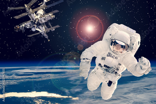 Fototapeta Naklejka Na Ścianę i Meble -  Astronaut and space station against earth. The elements of this image furnished by NASA.