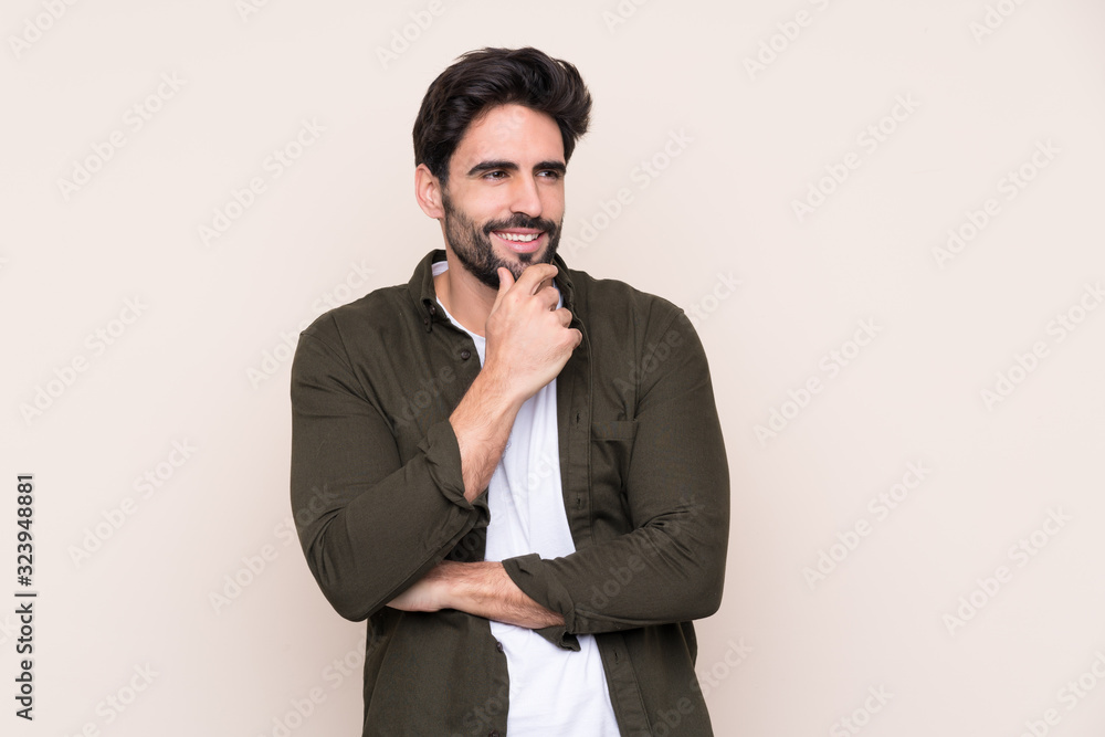Young handsome man with beard over isolated background looking to the side Young handsome man with beard over isolated background looking to the side