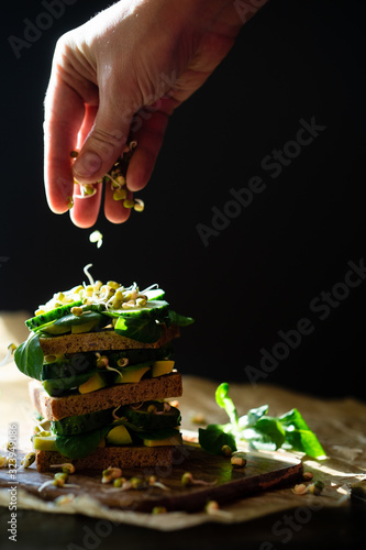 Vegetarian sandwich with fresh cucumber, avocado and corn salad leaves