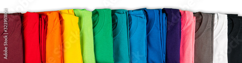 wide panorama row of many fresh new fabric cotton t-shirts in colorful rainbow colors isolated. Pile of various colored shirts white background photo