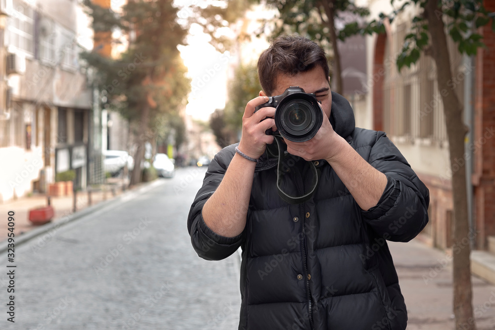 Young photographer taking photos on the streets of the city Young photographer taking photos on the streets of the city