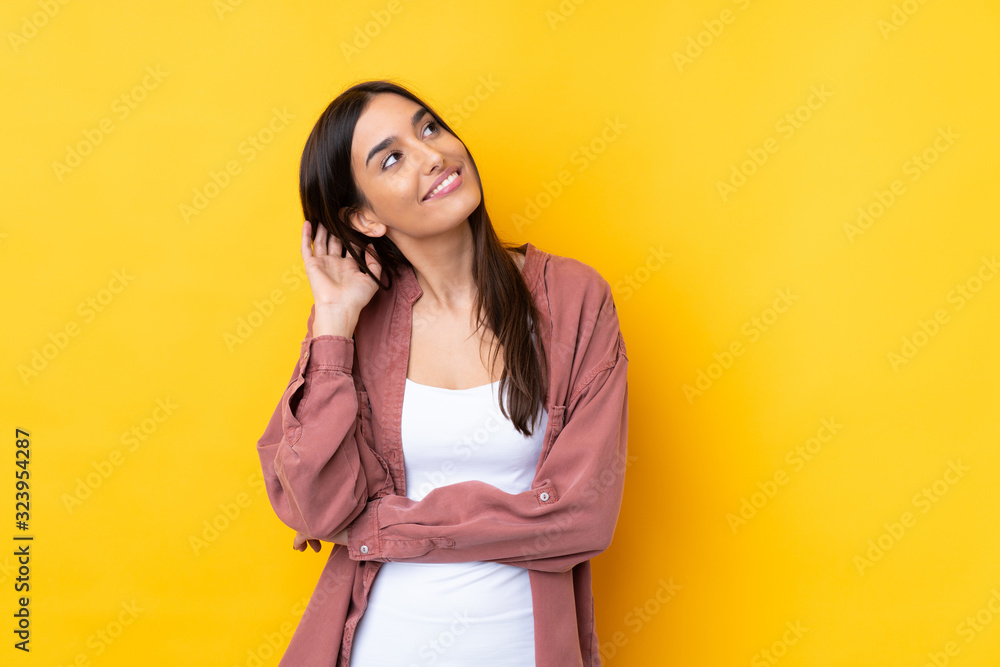 Young brunette woman over isolated yellow background thinking an idea Young brunette woman over isolated yellow background thinking an idea