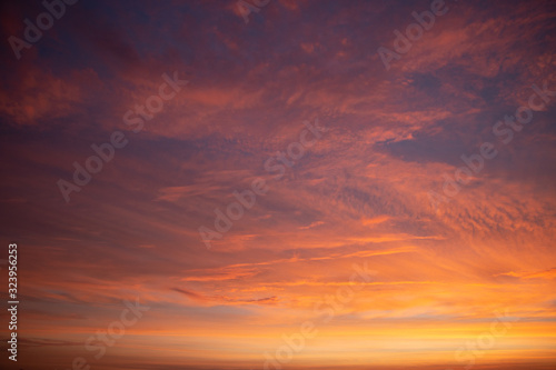 Beautiful colored cloudy skies in the colors blue, magenta, orange, purple, pink and yellow at sunrise in the Netherlands during the winter