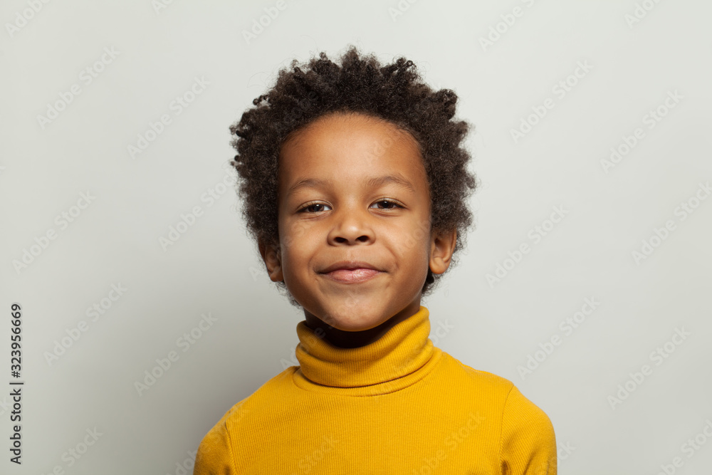 Handsome black child boy smiling and looking at camera on white background Handsome black child boy smiling and looking at camera on white background