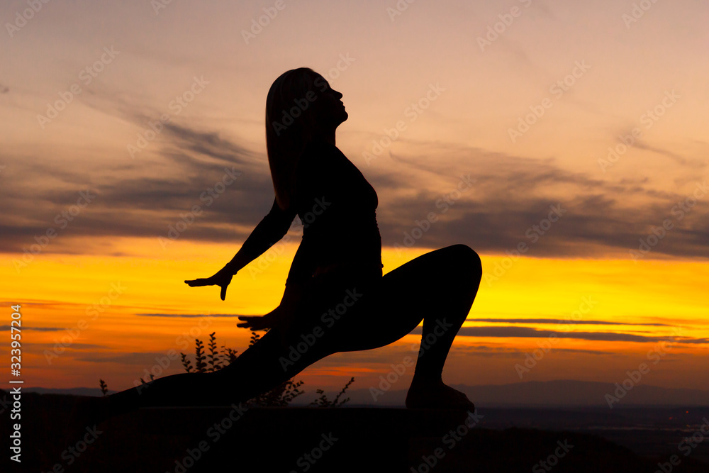 Silhouette woman yoga practice at sunset.Warrior I Virabhadrasana with variation