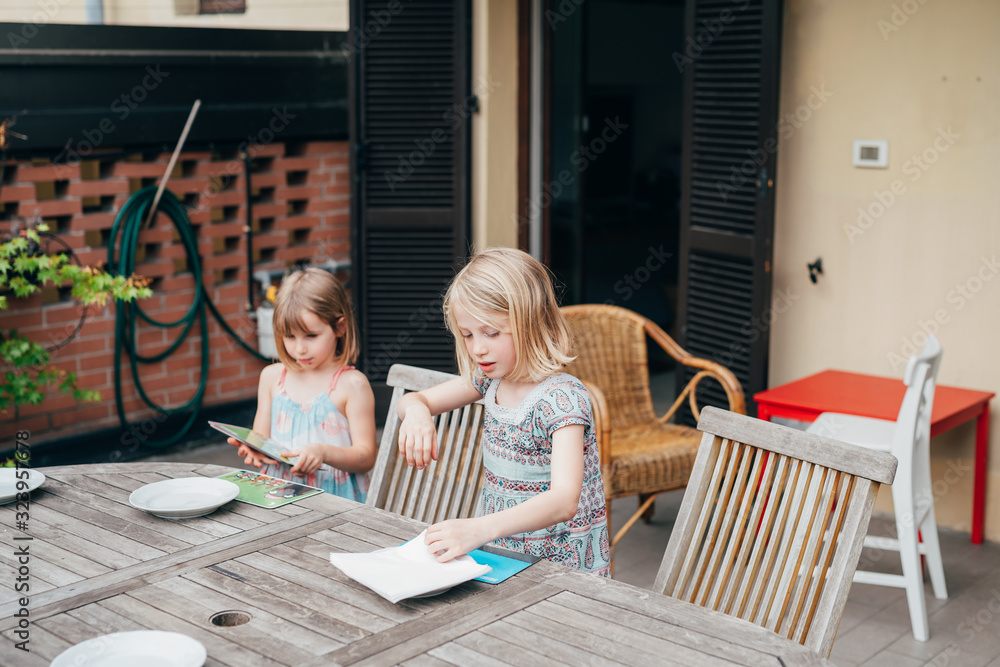 Two beautiful female children helping setting the table Two beautiful female children helping setting the table