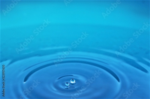 Splashing water drop on blue water background photo