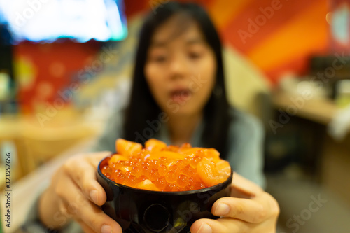 A woman carrying Salmon Roe Rice  Focus on rice