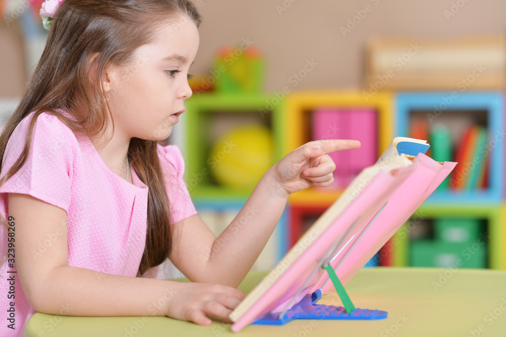 Portrait of cute little girl reading book Portrait of cute little girl reading book