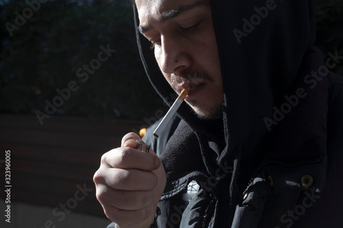 Young photographer smokes a cigarette on his break