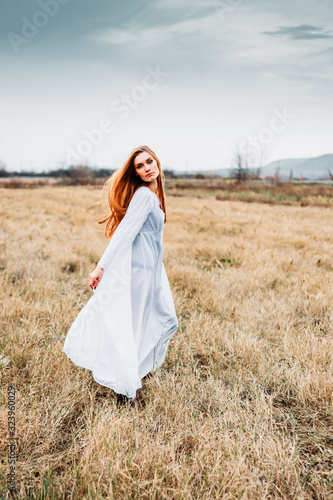 Beautiful girl in white nightgown, looking like a fairy on corn field.