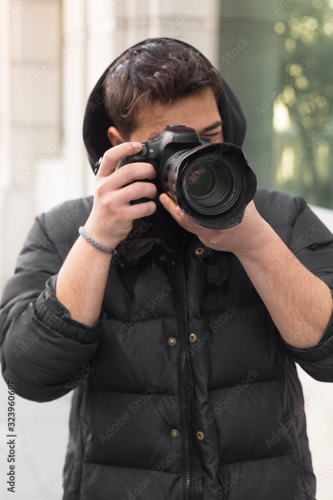 Young photographer taking photos on the streets of the city Young photographer taking photos on the streets of the city