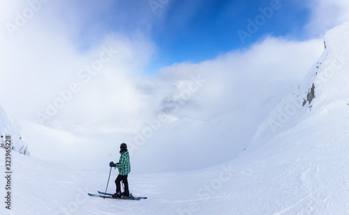 Adventurous Girl Skiing on a beautiful snowy mountain during a vibrant and sunny winter day. Taken in Whistler  British Columbia  Canada.