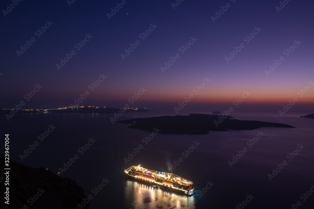 Cruise ship at berth at the blue hour, in the bay, at the island of Santorini, Greece.