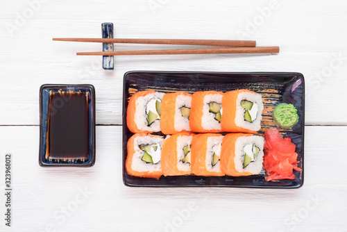 Sushi roll Philadelphia on the plate over white wooden table background.