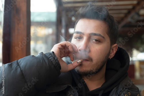Obraz na płótnie Young man smokes in a cafe