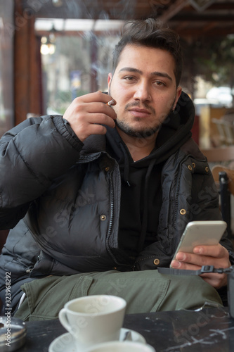 Obraz na płótnie Young man smokes in a cafe