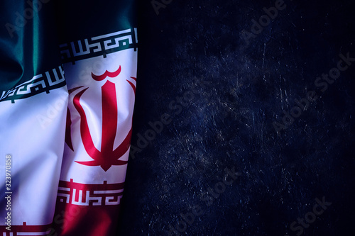 National flag of Iran on a dark background with space for text.