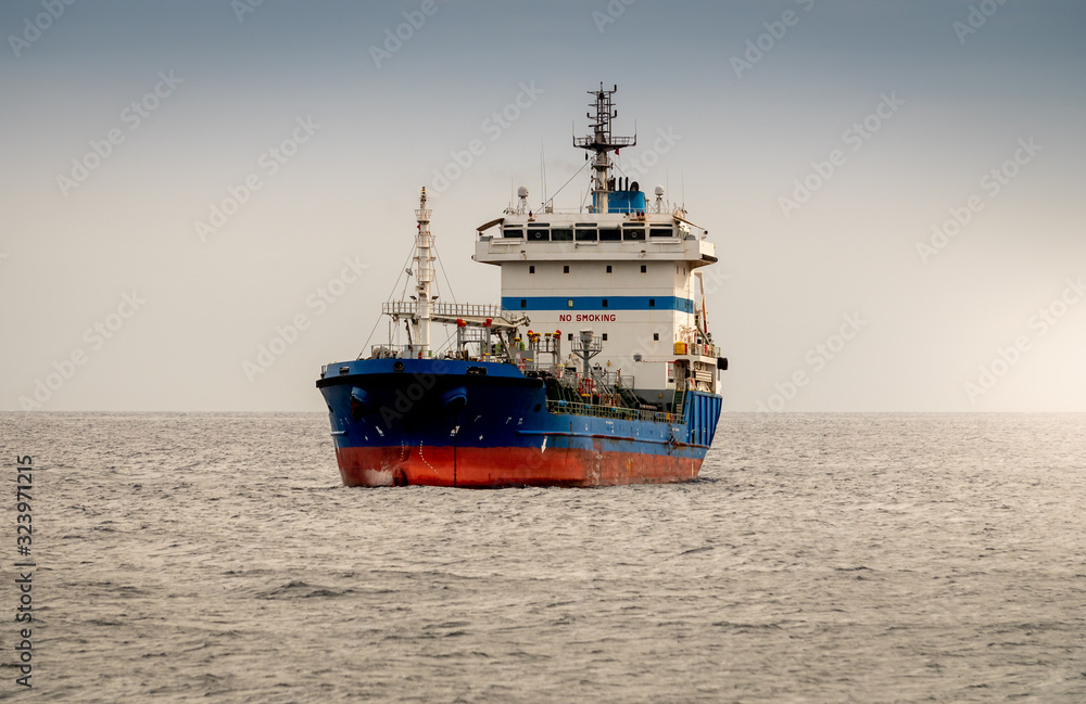 Beautiful image of old rusty cargo ship or oil tanker in the ocean at sunset light Beautiful image of old rusty cargo ship or oil tanker in the ocean at sunset light