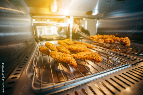 Chef's hand taking Crispy chicken nuggets close-up in a restaurant