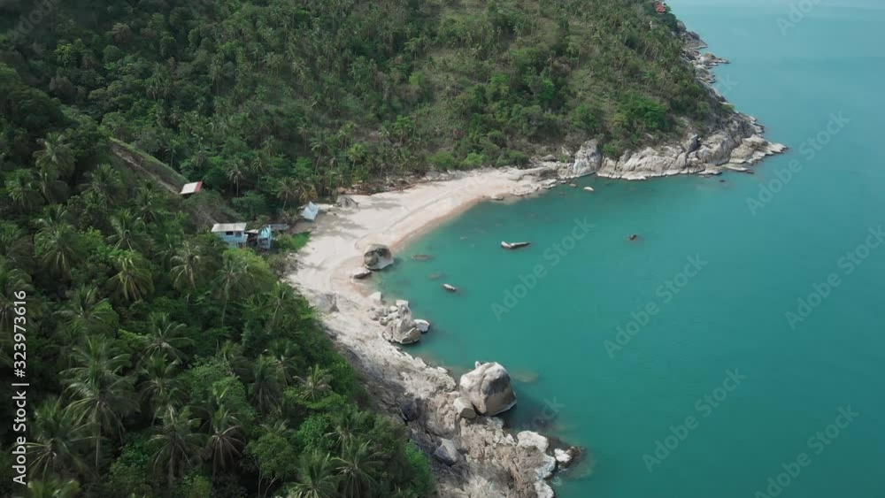 Aerial view of scenery beach. Travel to wild jungles of Thailand. Sea waves leak white sand. Palm trees pass below the drone Aerial view of scenery beach. Travel to wild jungles of Thailand. Sea waves leak white sand. Palm trees pass below the drone